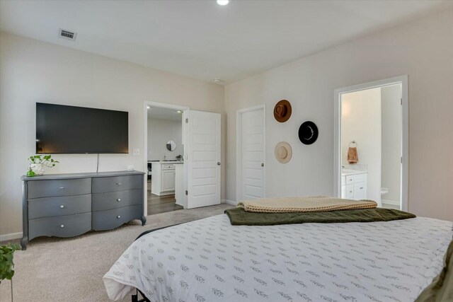 bedroom with visible vents, baseboards, carpet, and ensuite bathroom