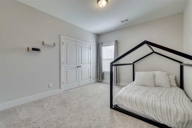 carpeted bedroom featuring a closet, visible vents, and baseboards