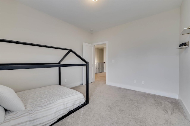 bedroom with light carpet and baseboards