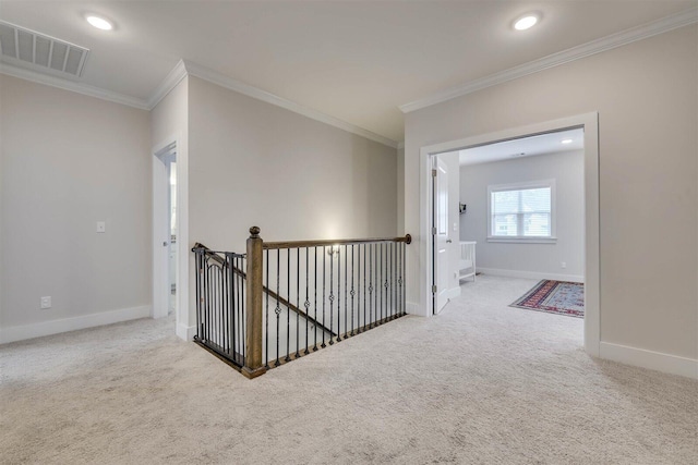 hall featuring carpet floors, baseboards, visible vents, and crown molding