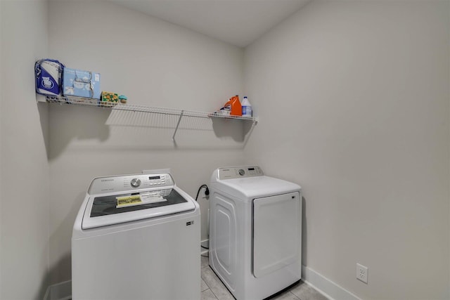 laundry area with light tile patterned floors, laundry area, separate washer and dryer, and baseboards