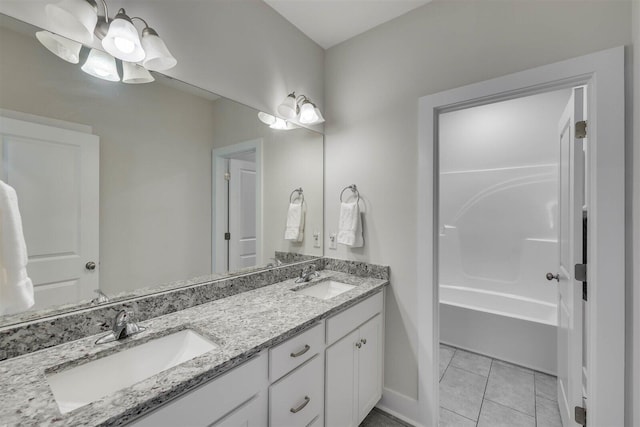 full bathroom with double vanity, tile patterned flooring, baseboards, and a sink