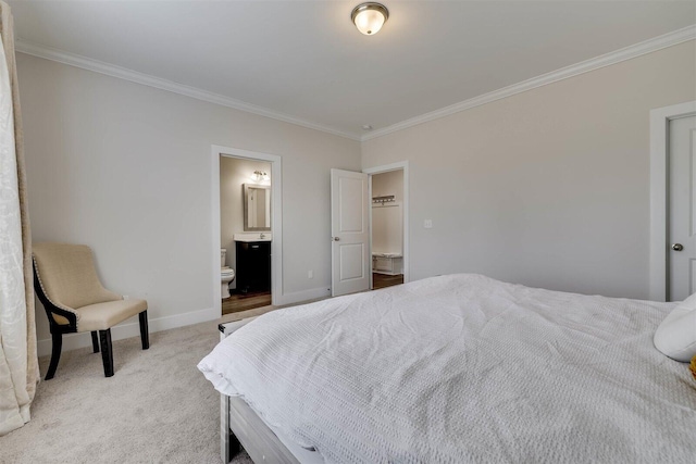 bedroom with baseboards, ornamental molding, ensuite bathroom, and light colored carpet