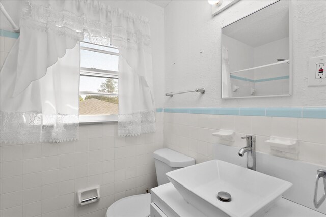 2905 Rocky Creek Rd, Augusta, GA 30906 - bathroom featuring a sink, tile walls, a wainscoted wall, and toilet