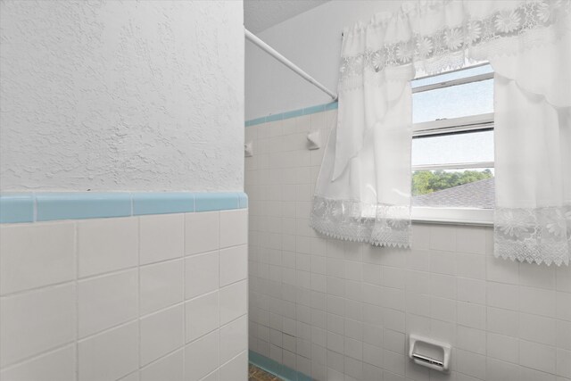 2905 Rocky Creek Rd, Augusta, GA 30906 - full bathroom featuring wainscoting, tile walls, and a tile shower