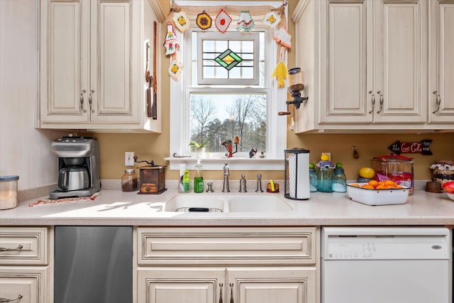 kitchen featuring sink, white dishwasher, and cream cabinetry