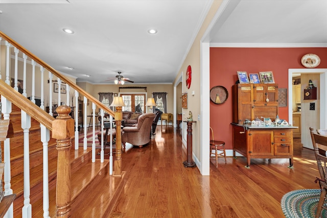 foyer entrance with ceiling fan, crown molding, and light hardwood / wood-style flooring