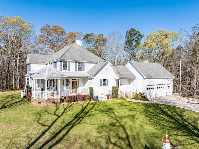 view of front of property featuring a front yard, a garage, and covered porch