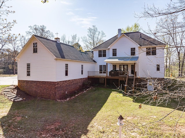 rear view of property with a lawn and a wooden deck