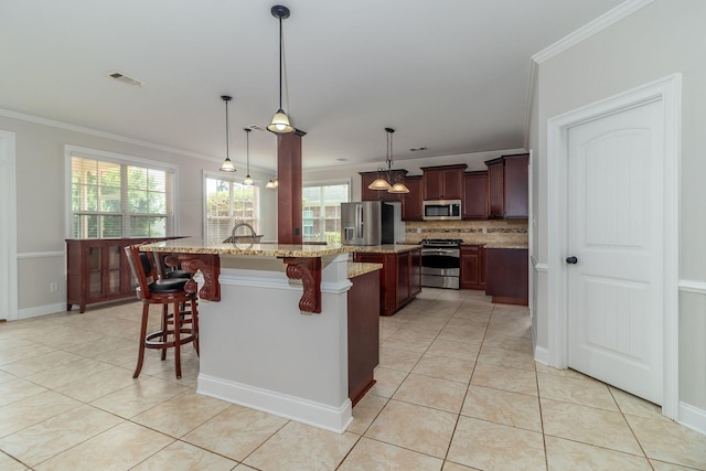 5191 Windmill Pl, Evans, GA 30809 - kitchen featuring appliances with stainless steel finishes, tasteful backsplash, a kitchen bar, ornamental molding, and light tile patterned floors