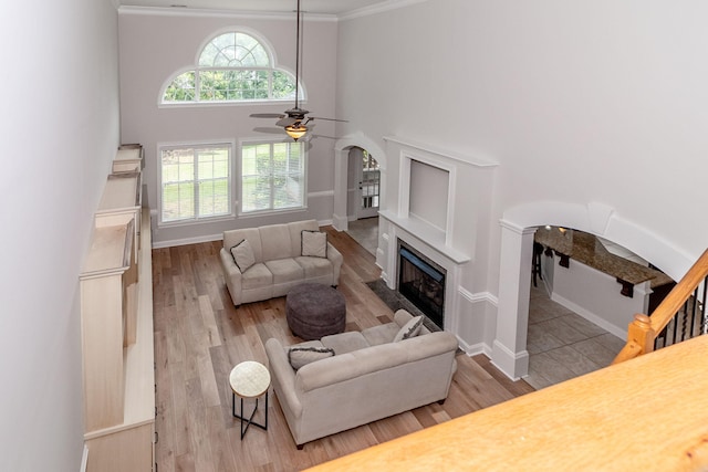 5191 Windmill Pl, Evans, GA 30809 - living area featuring arched walkways, a ceiling fan, a fireplace, wood finished floors, and a towering ceiling