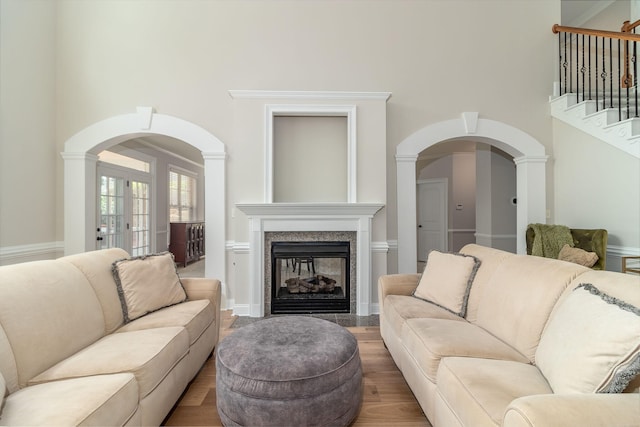 5191 Windmill Pl, Evans, GA 30809 - living area with a high ceiling, arched walkways, a fireplace, wood finished floors, and stairway