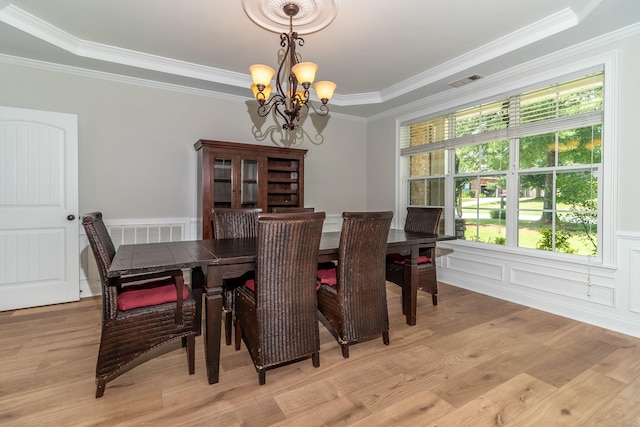 5191 Windmill Pl, Evans, GA 30809 - dining room featuring a chandelier, crown molding, light wood-type flooring, a wainscoted wall, and a raised ceiling
