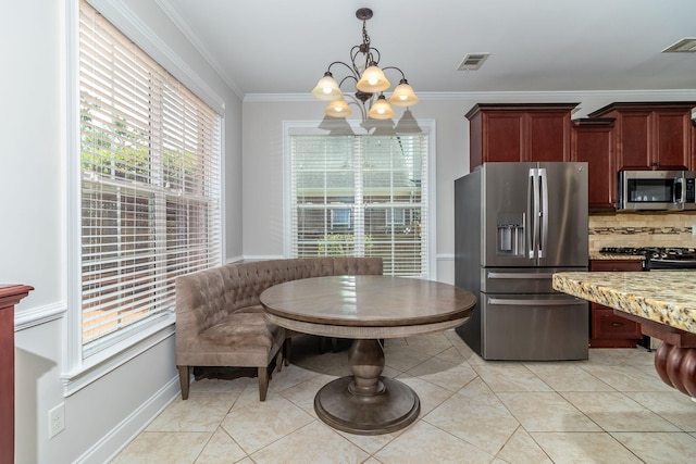 5191 Windmill Pl, Evans, GA 30809 - kitchen with appliances with stainless steel finishes, a chandelier, light stone countertops, pendant lighting, and light tile patterned floors