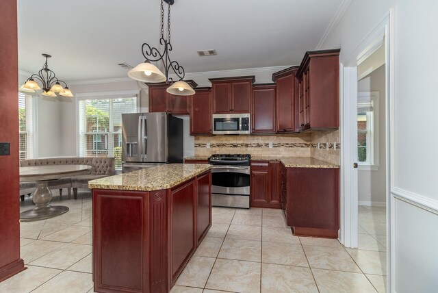 5191 Windmill Pl, Evans, GA 30809 - kitchen with stainless steel appliances, reddish brown cabinets, decorative backsplash, a chandelier, and crown molding