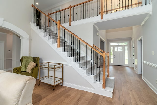 5191 Windmill Pl, Evans, GA 30809 - entrance foyer featuring a towering ceiling, arched walkways, wood finished floors, stairway, and crown molding
