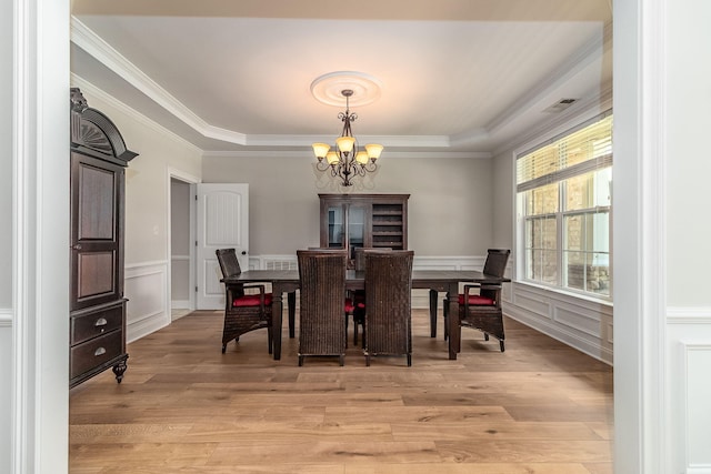 5191 Windmill Pl, Evans, GA 30809 - dining area with a chandelier, light wood-type flooring, crown molding, a decorative wall, and wainscoting