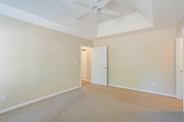 carpeted spare room with ceiling fan and baseboards