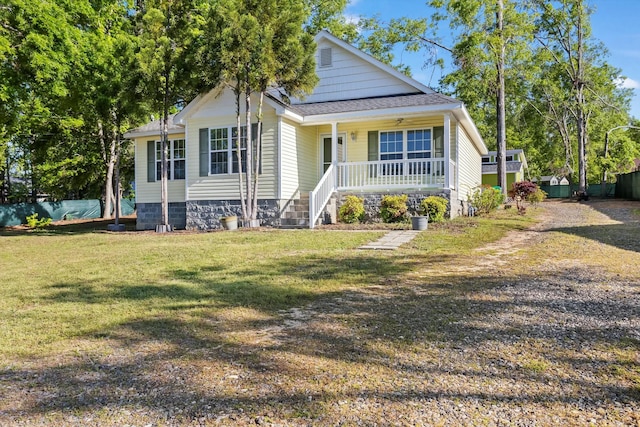 bungalow-style home featuring roof with shingles, a front lawn, and covered porch
