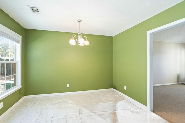 empty room featuring visible vents, baseboards, and an inviting chandelier