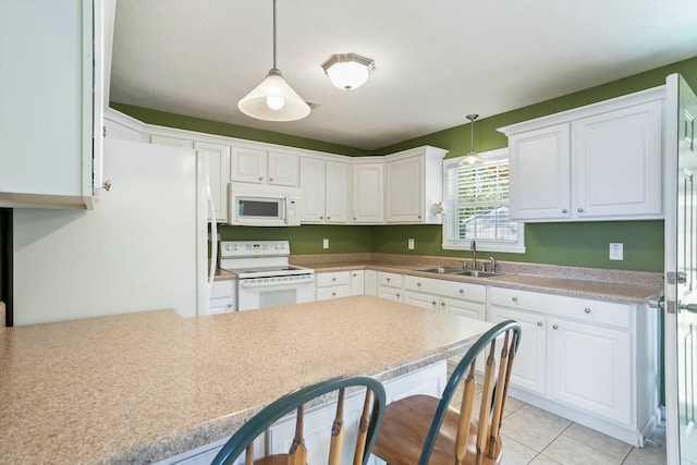 kitchen featuring decorative light fixtures, a sink, white appliances, and white cabinets