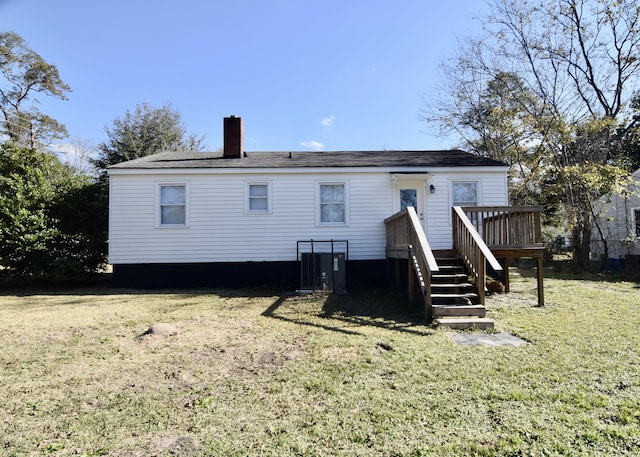 rear view of house featuring a yard and a deck