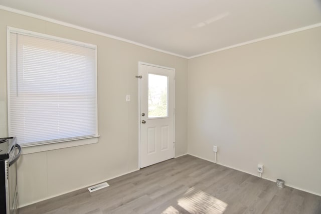 entryway with light hardwood / wood-style floors and crown molding