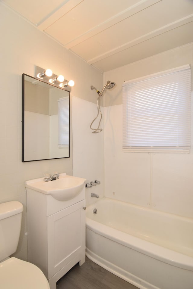 full bathroom featuring hardwood / wood-style floors, vanity,  shower combination, and toilet