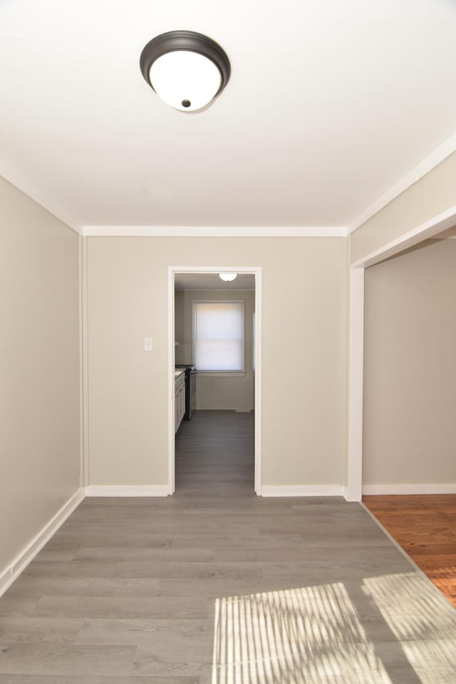 hallway with wood-type flooring and crown molding