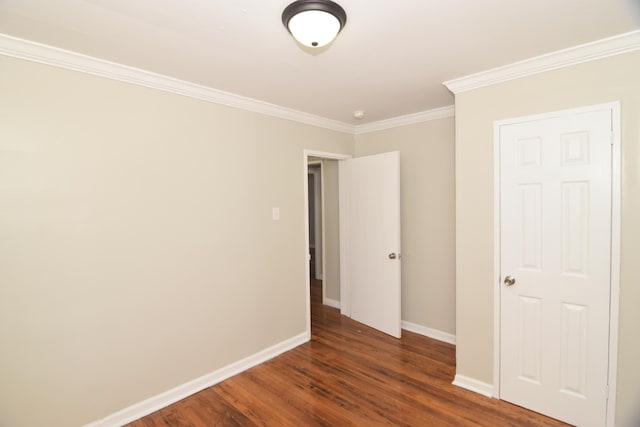 empty room featuring dark hardwood / wood-style floors and ornamental molding