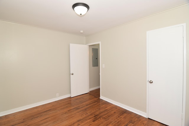 spare room with dark hardwood / wood-style flooring, ornamental molding, and electric panel