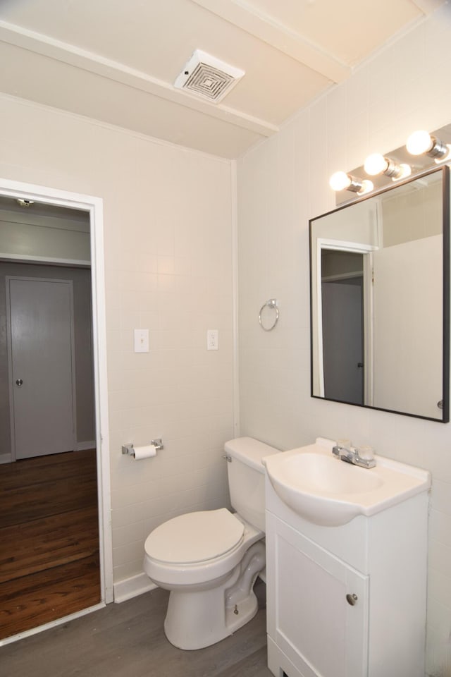 bathroom featuring wood-type flooring, vanity, and toilet