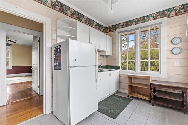 kitchen with white cabinets, light tile patterned floors, white fridge, and ceiling fan