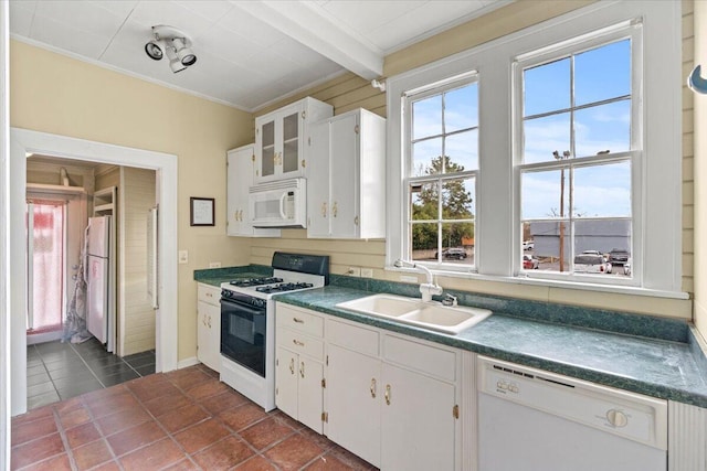 kitchen featuring white appliances, dark tile patterned floors, sink, beamed ceiling, and white cabinets