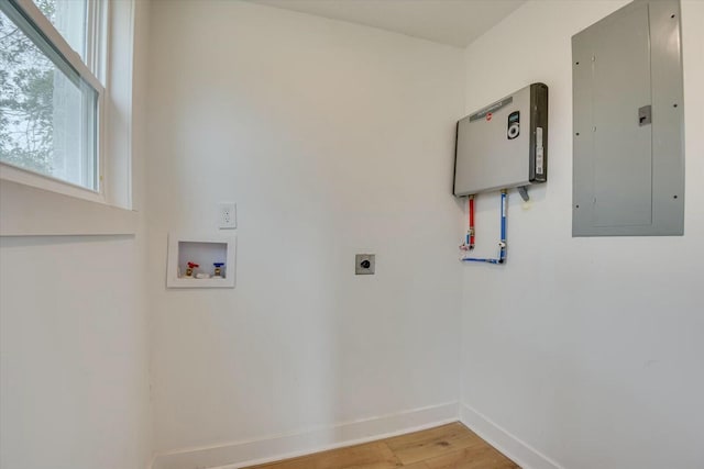 clothes washing area featuring hardwood / wood-style floors, hookup for a washing machine, electric panel, and hookup for an electric dryer