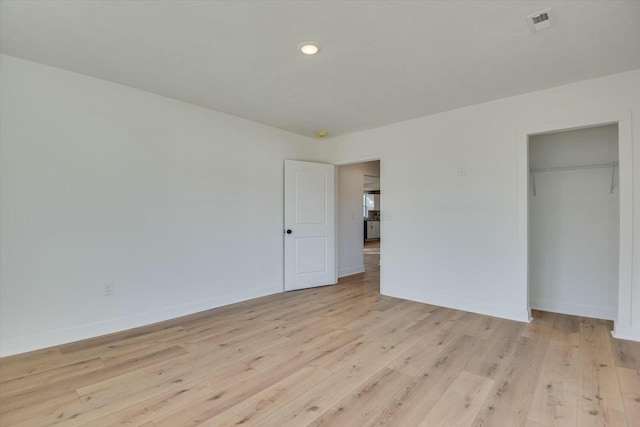 unfurnished bedroom with a closet and light hardwood / wood-style flooring