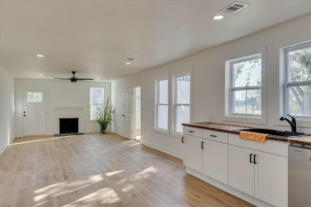 kitchen with ceiling fan, sink, light hardwood / wood-style flooring, dishwasher, and white cabinetry