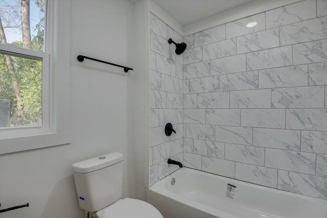 bathroom with tiled shower / bath combo and toilet