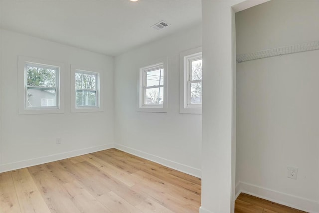 unfurnished bedroom featuring light hardwood / wood-style flooring and multiple windows