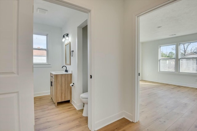 hallway featuring sink and light hardwood / wood-style flooring