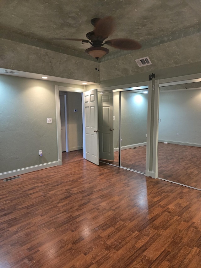 unfurnished bedroom featuring ceiling fan and dark hardwood / wood-style floors