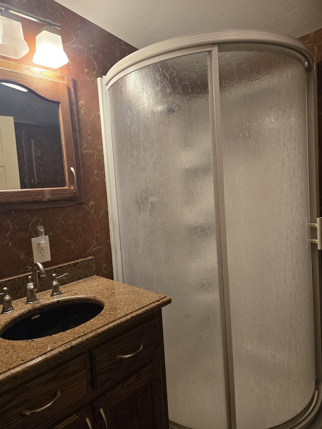 bathroom featuring an enclosed shower and vanity