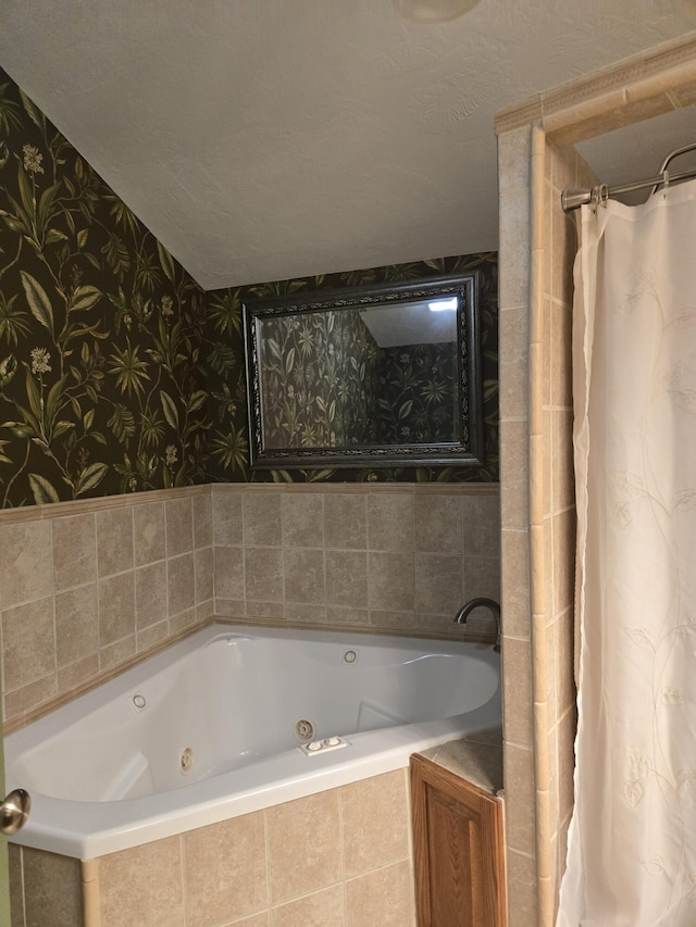 bathroom featuring a textured ceiling and tiled tub