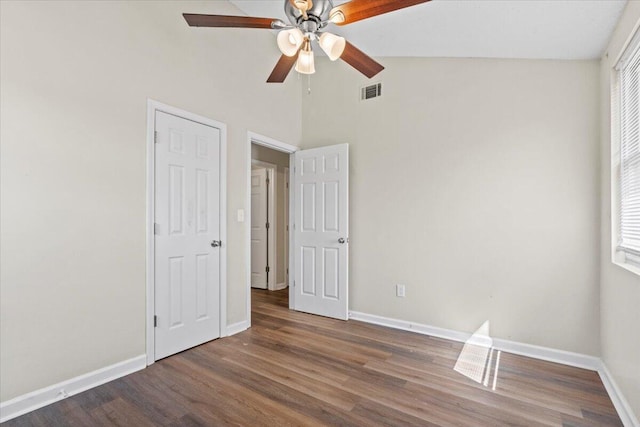 unfurnished bedroom with visible vents, ceiling fan, vaulted ceiling, wood finished floors, and baseboards