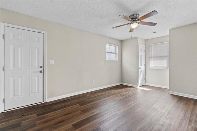 empty room with ceiling fan, a textured ceiling, wood finished floors, and baseboards