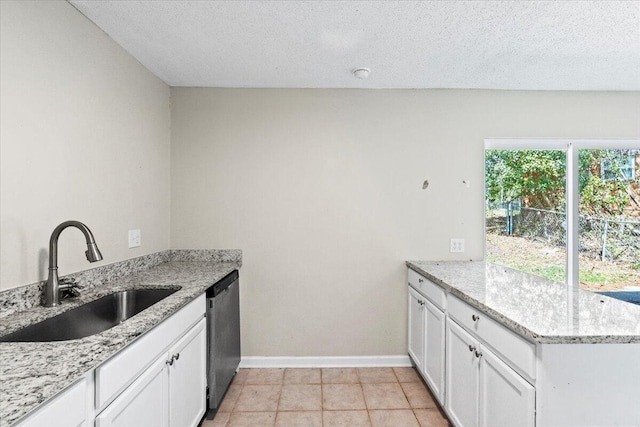 kitchen with white cabinets, a sink, a peninsula, and dishwasher