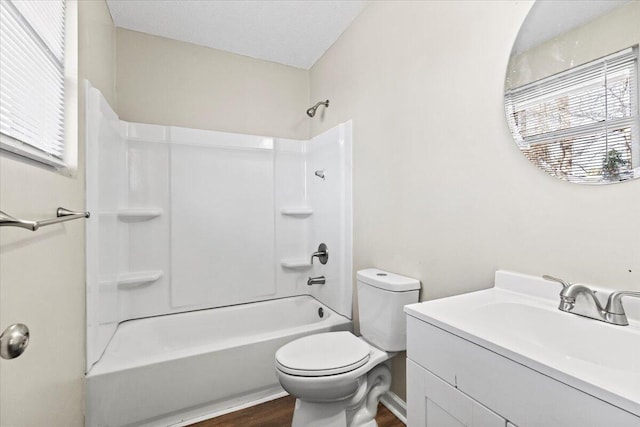 full bathroom featuring bathing tub / shower combination, toilet, a textured ceiling, vanity, and wood finished floors