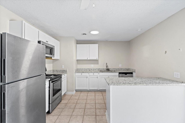 kitchen with white cabinets, light tile patterned floors, stainless steel appliances, and a sink