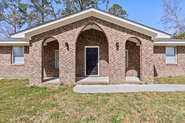 view of front of home featuring a front lawn and brick siding