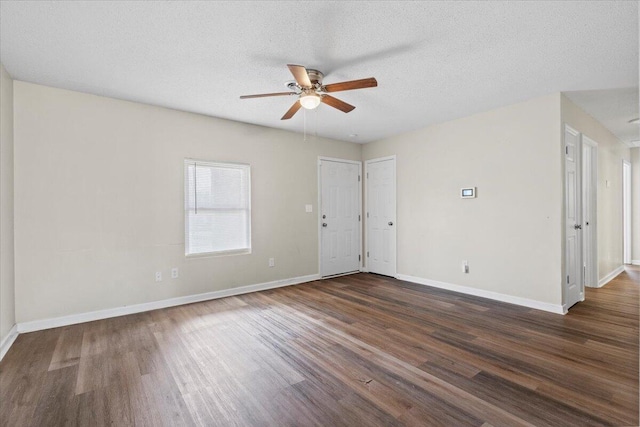 unfurnished room featuring a ceiling fan, a textured ceiling, baseboards, and dark wood-type flooring